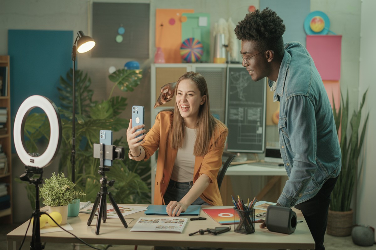 Marketeurs filmant publicité selfie authentique dans studio créatif urbain lumineux