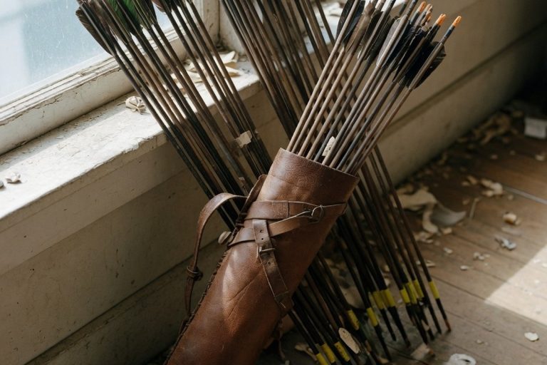 Quiver en cuir rempli de flèches sur parquet clair sous lumière naturelle douce